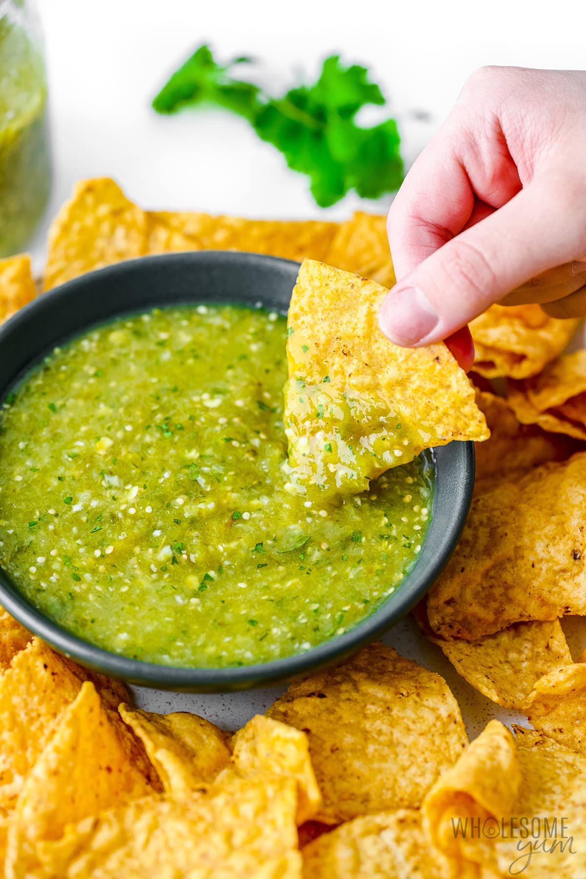 Tomatillo salsa with chip dunked in it.