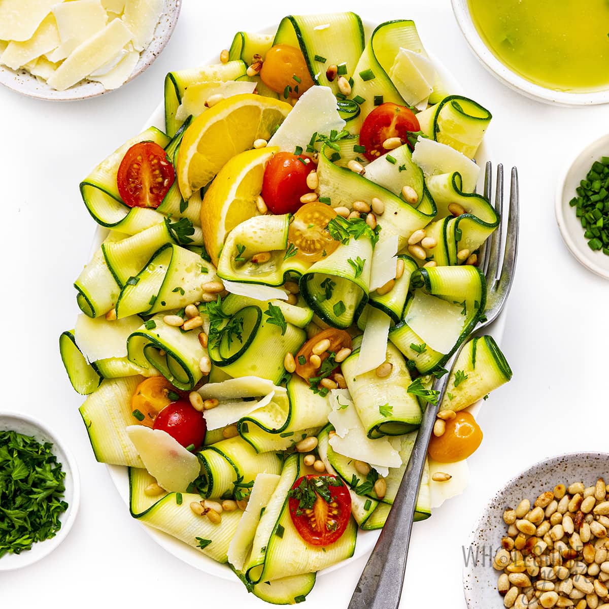 Zucchini salad on a platter with a fork.