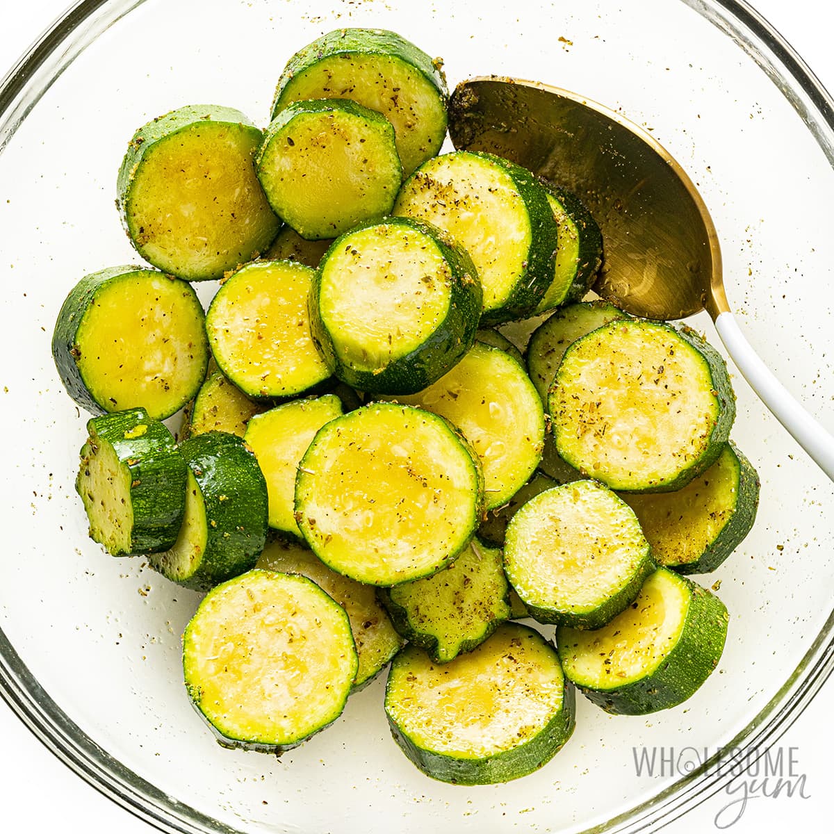 Zucchini seasoned with spices and tossed in a bowl.