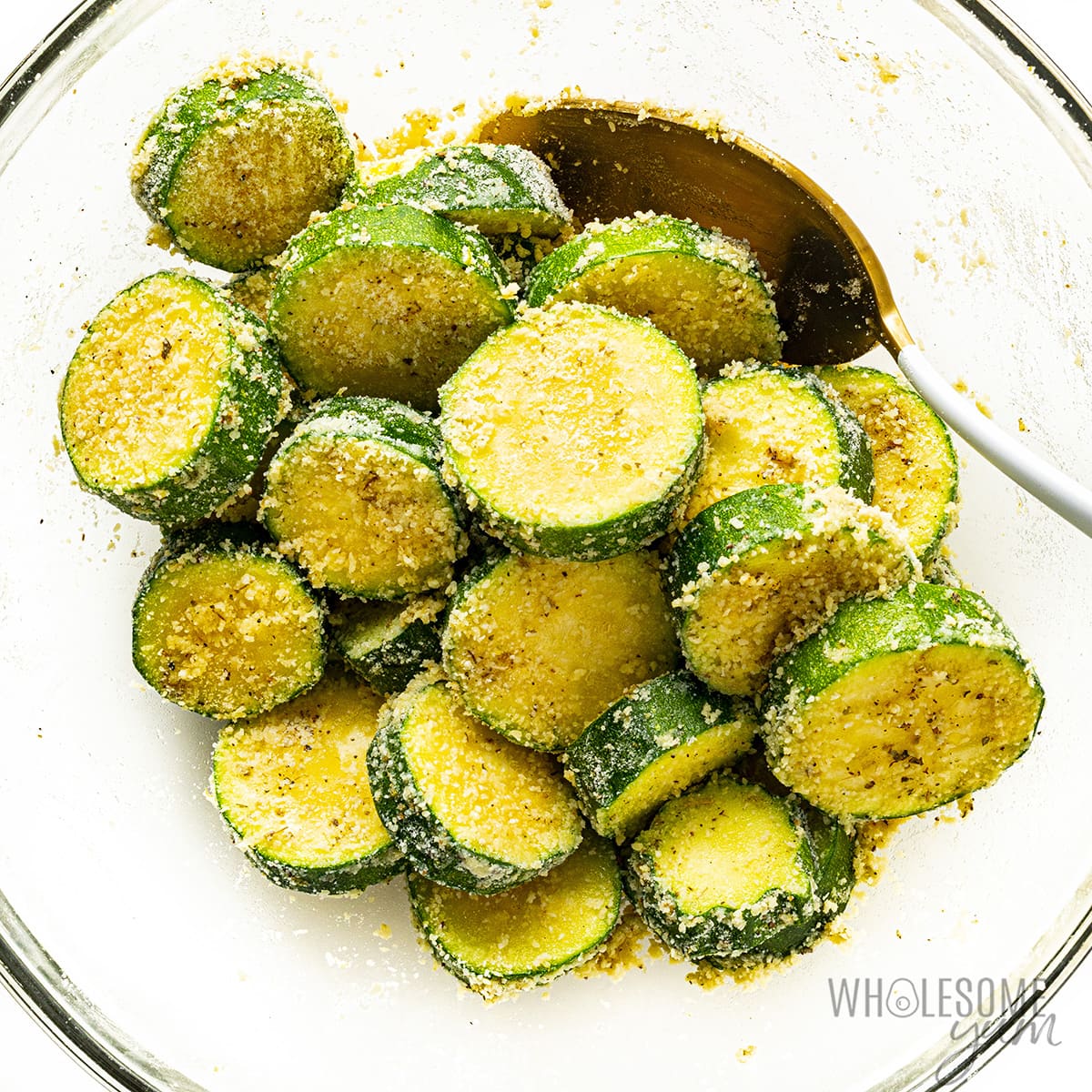 Zucchini sprinkled with grated parmesan in a bowl.