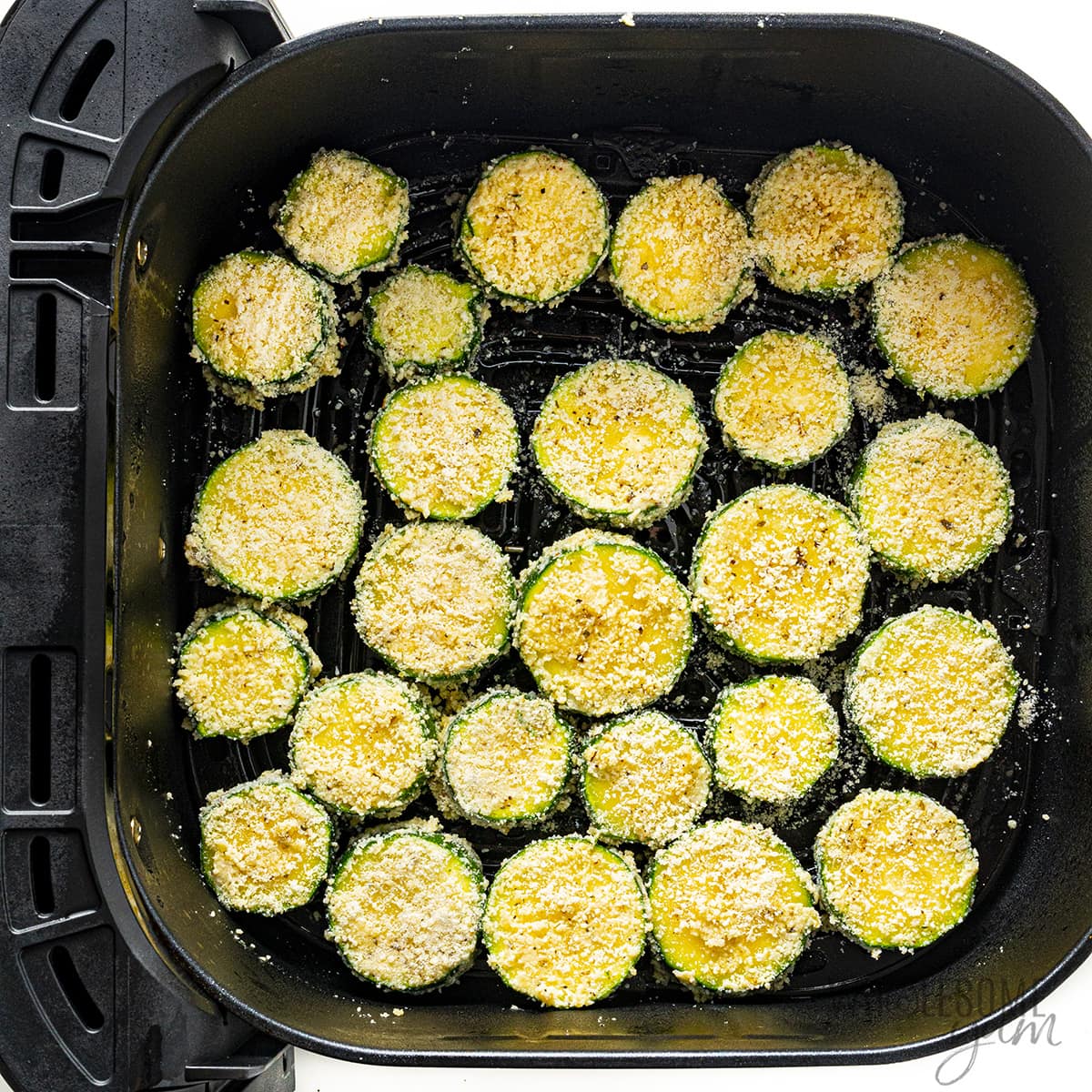 Zucchini in air fryer basket before cooking.