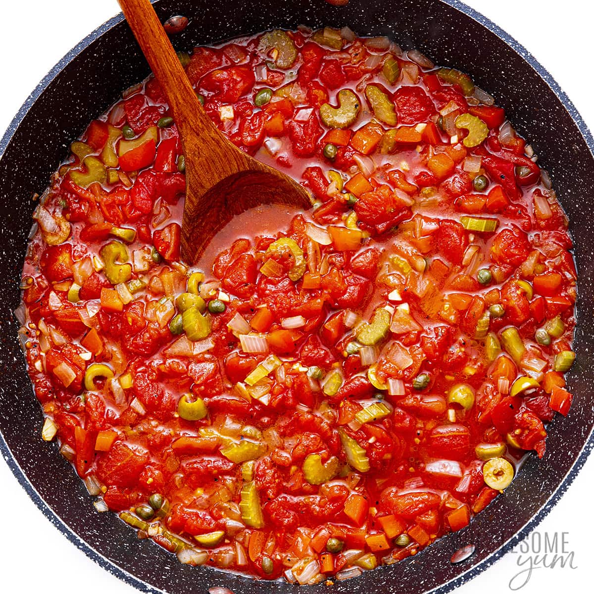 Diced tomatoes added to veggies in a skillet.