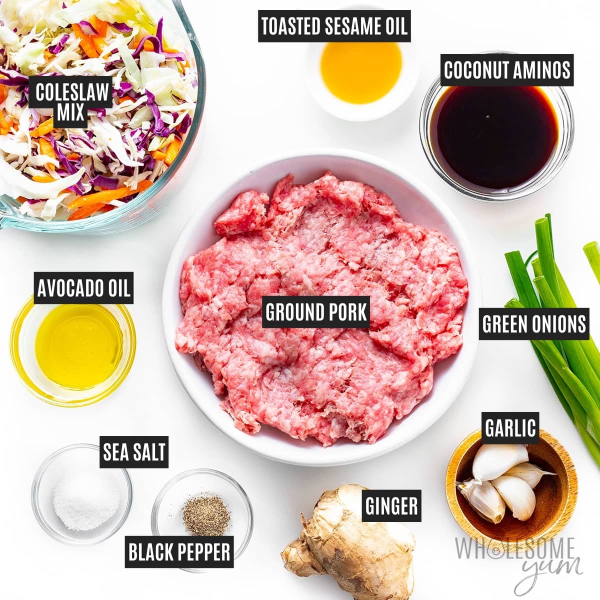 Ground sausage in a bowl next to cabbage, garlic, ginger, and other recipe ingredients.
