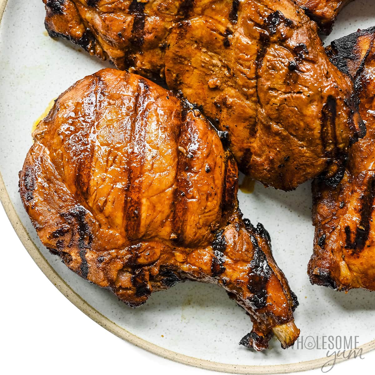 Grilled pork chops resting on a plate.