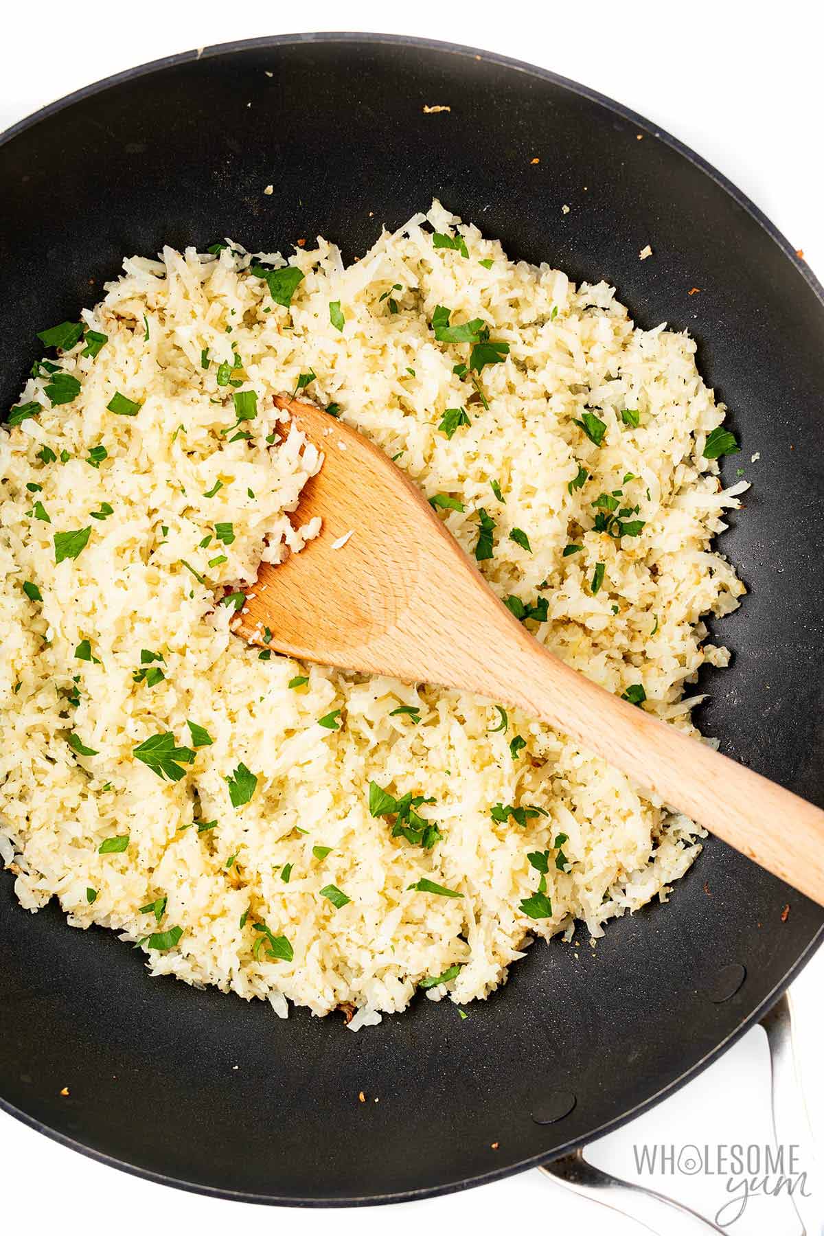 Cooked cauliflower rice in a skillet.