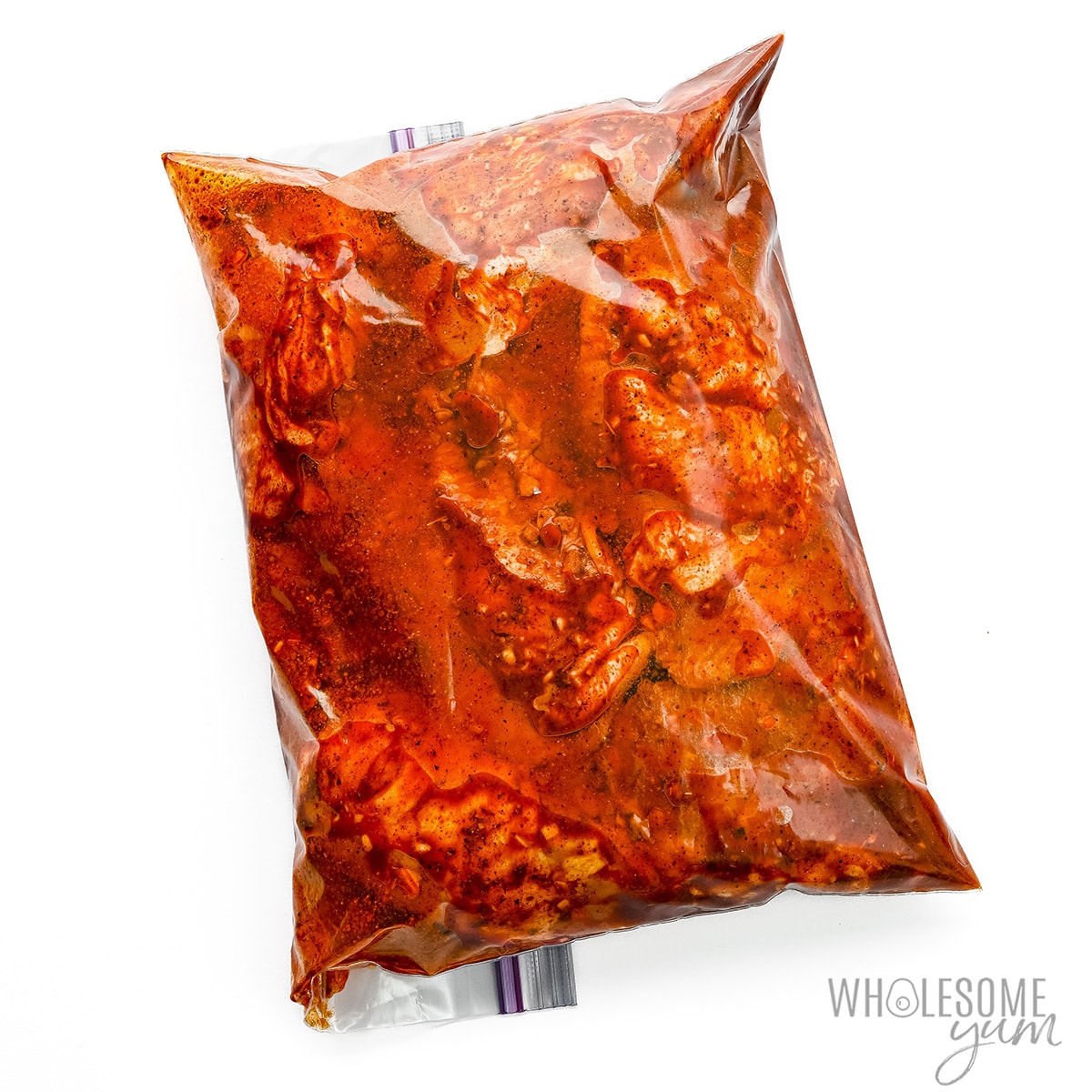 Chicken marinating in a bag.