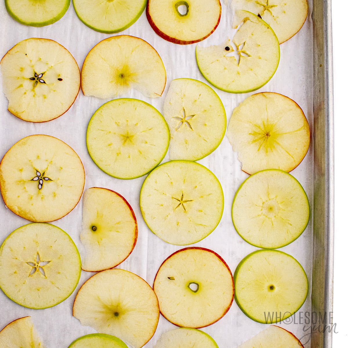 Apple slices arranged on a baking sheet.