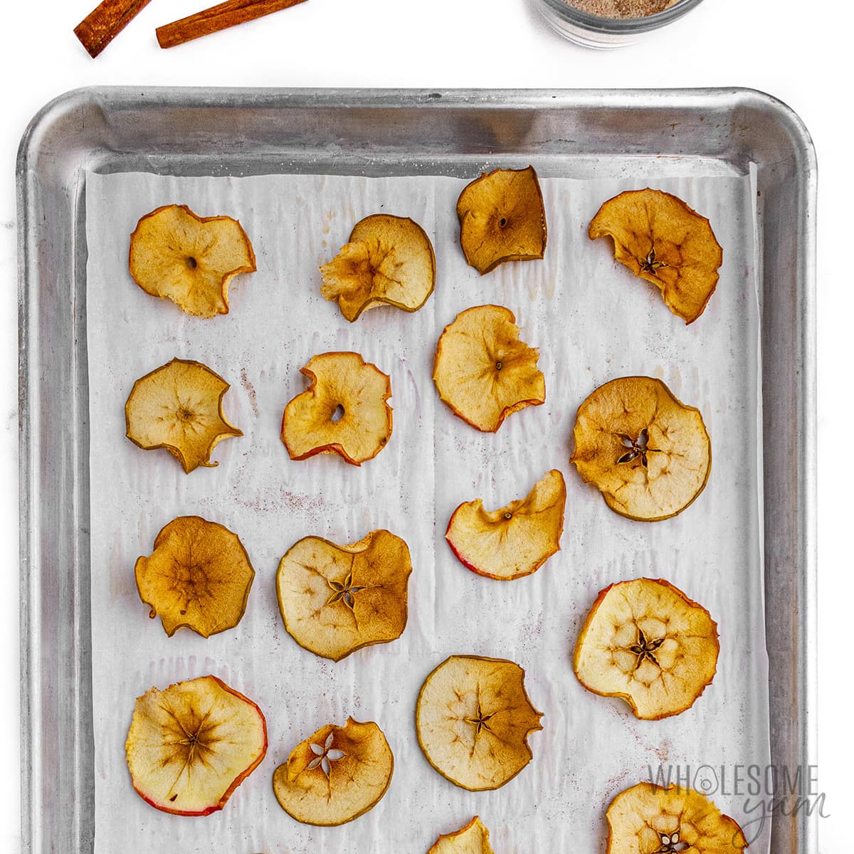 Baked apple chips on a baking sheet.