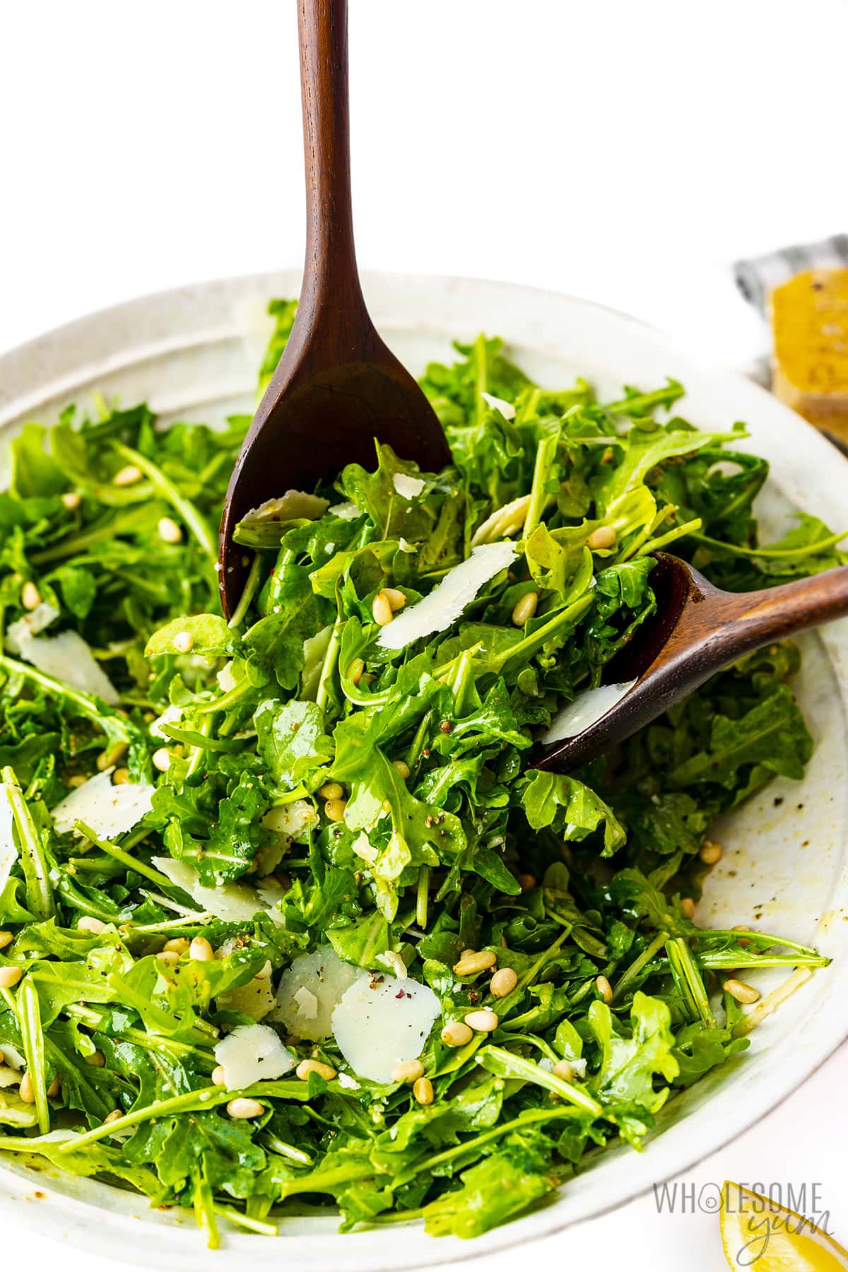 Arugula salad served with wooden spoons.