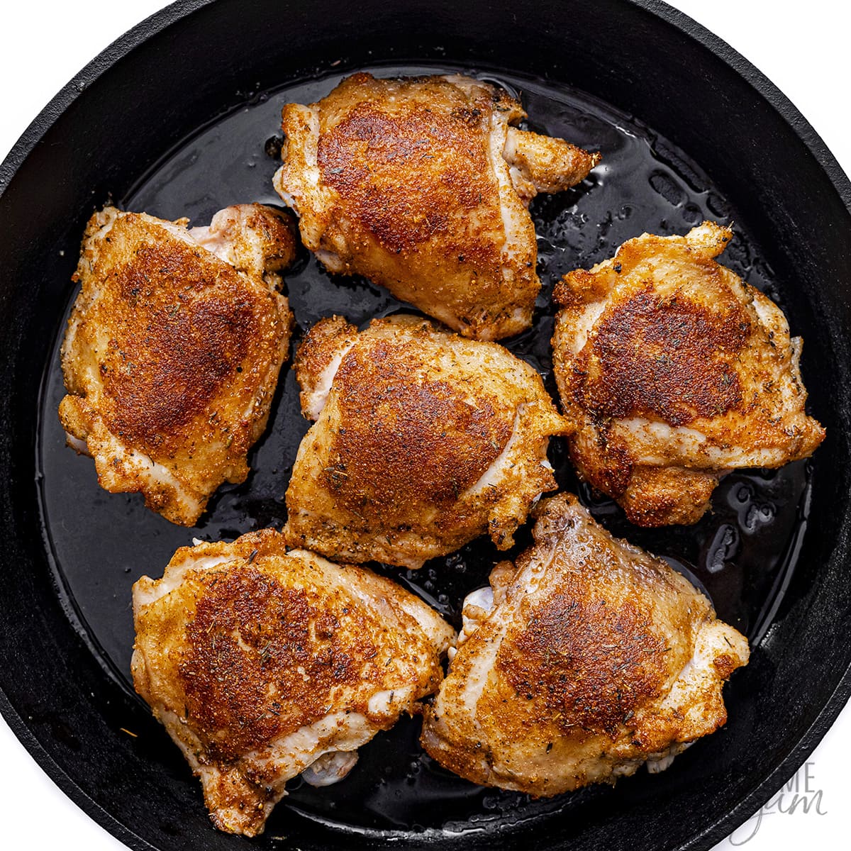 Chicken is seared in a cast iron skillet.
