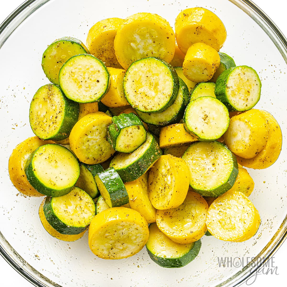 Veggies drizzled with olive oil and seasoned in a bowl.