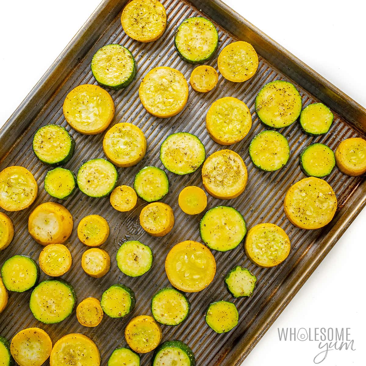 Zucchini and squash arranged on a baking sheet.