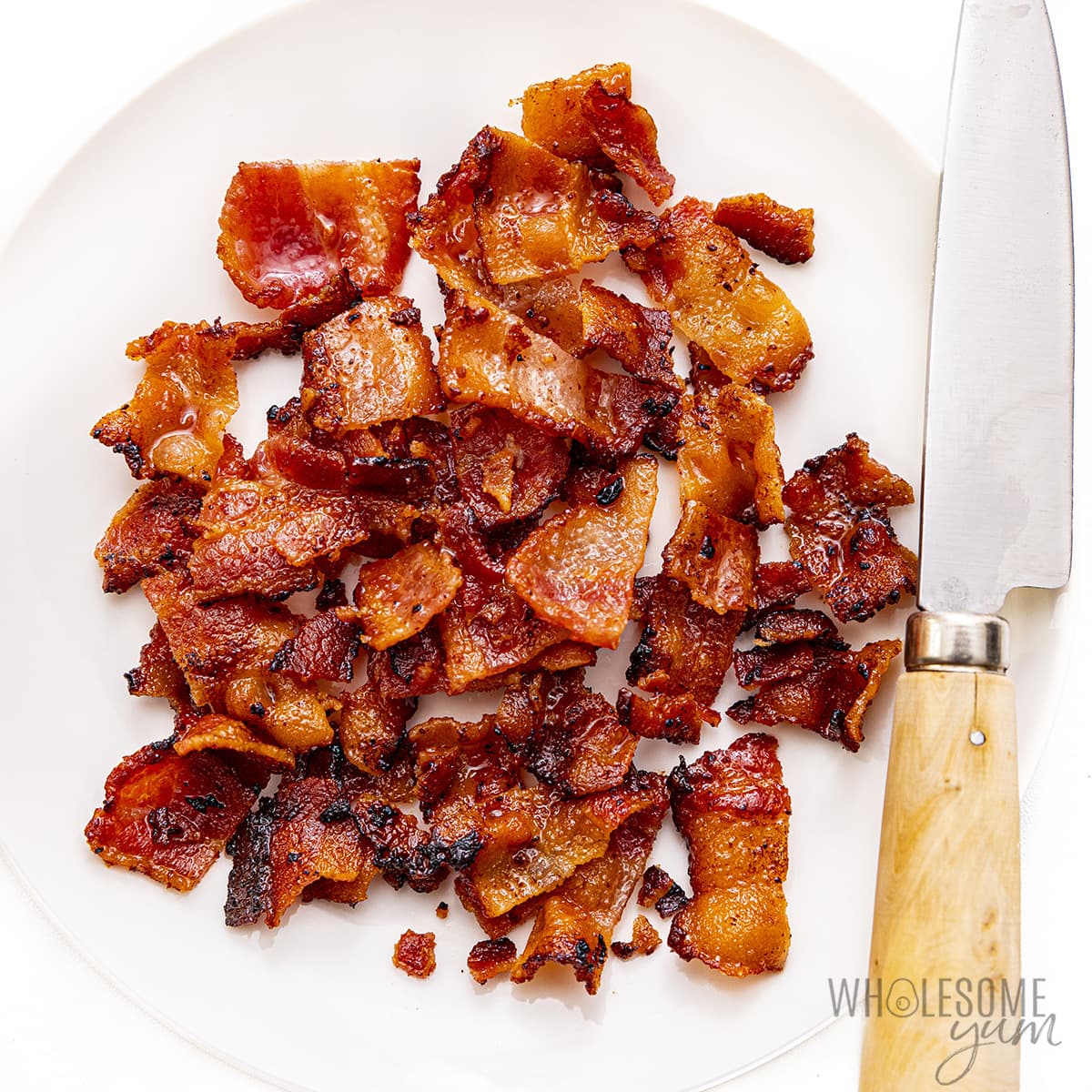 Bacon chopped into pieces on a plate.