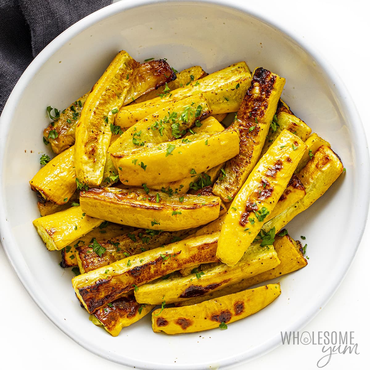Baked yellow summer squash in a bowl.