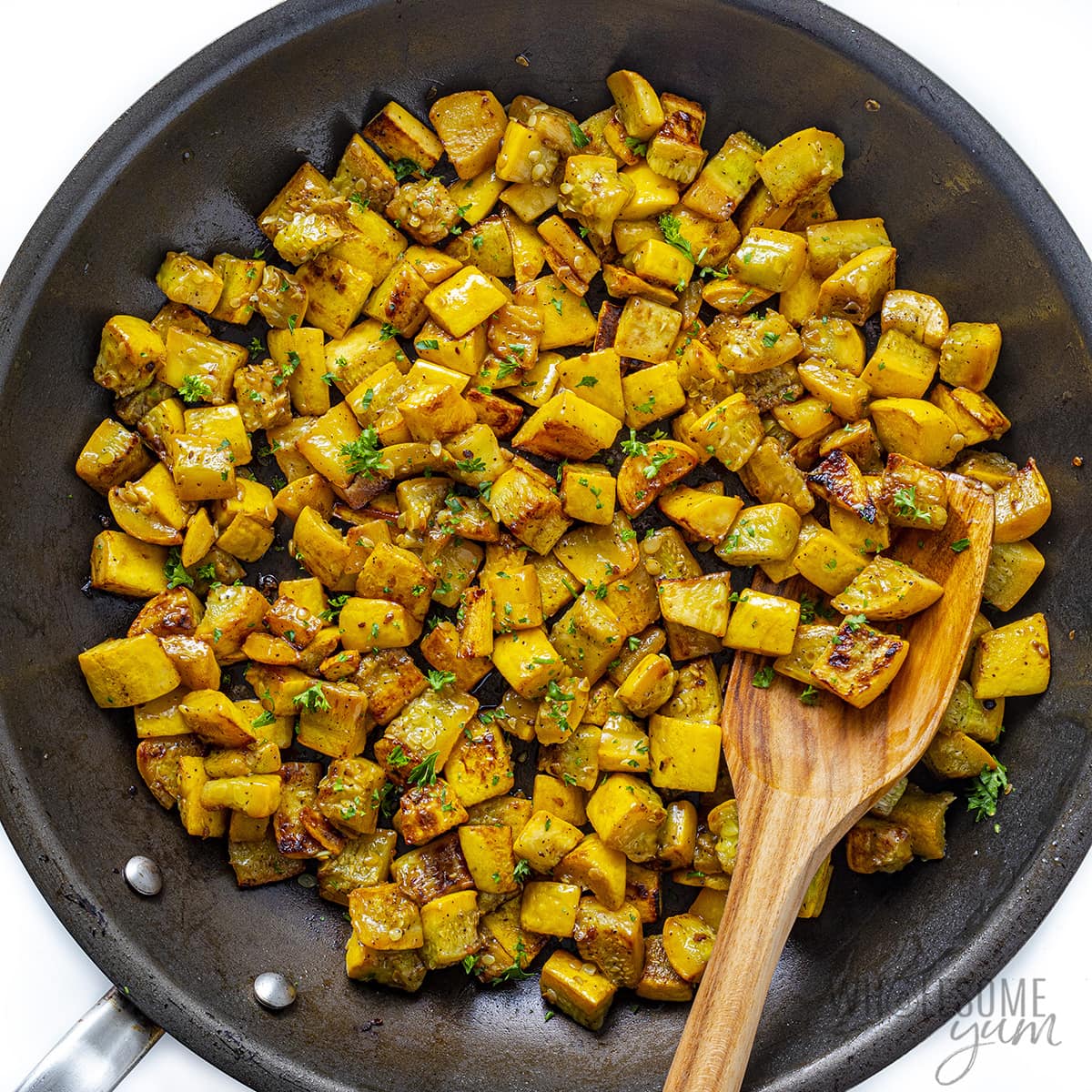 Sauteed yellow squash in a skillet.