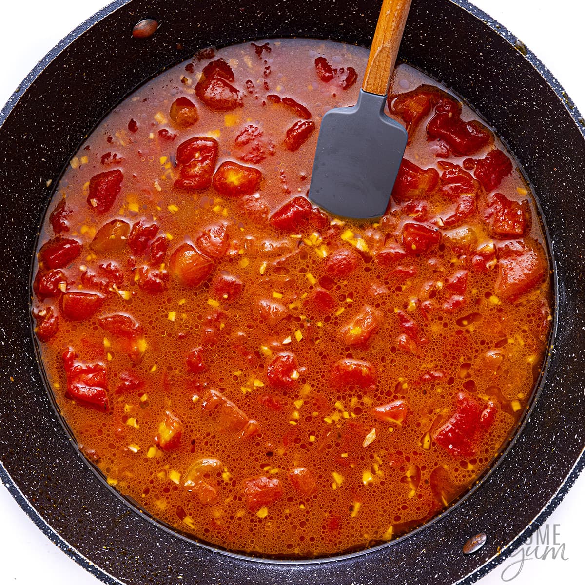 Diced tomatoes and broth added to skillet.