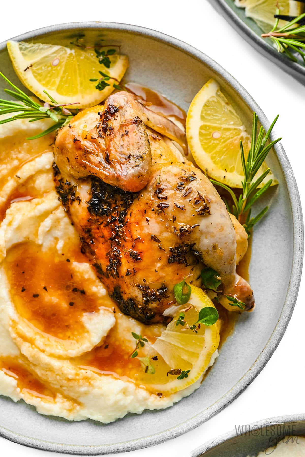 Cornish hen recipe served on a plate with mashed cauliflower.