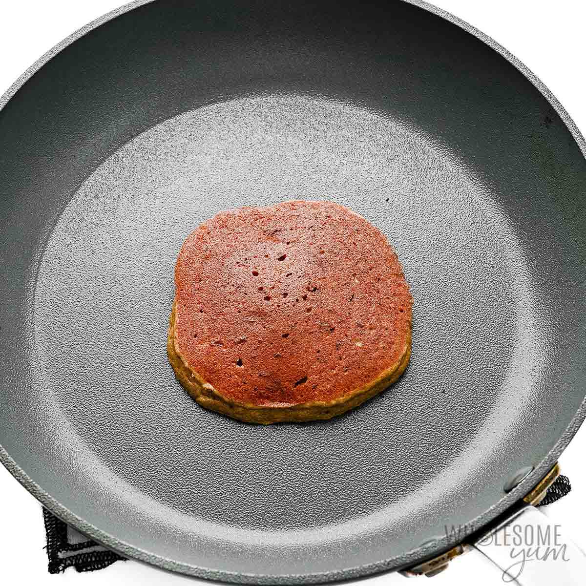 Pancake being cooked in a skillet.