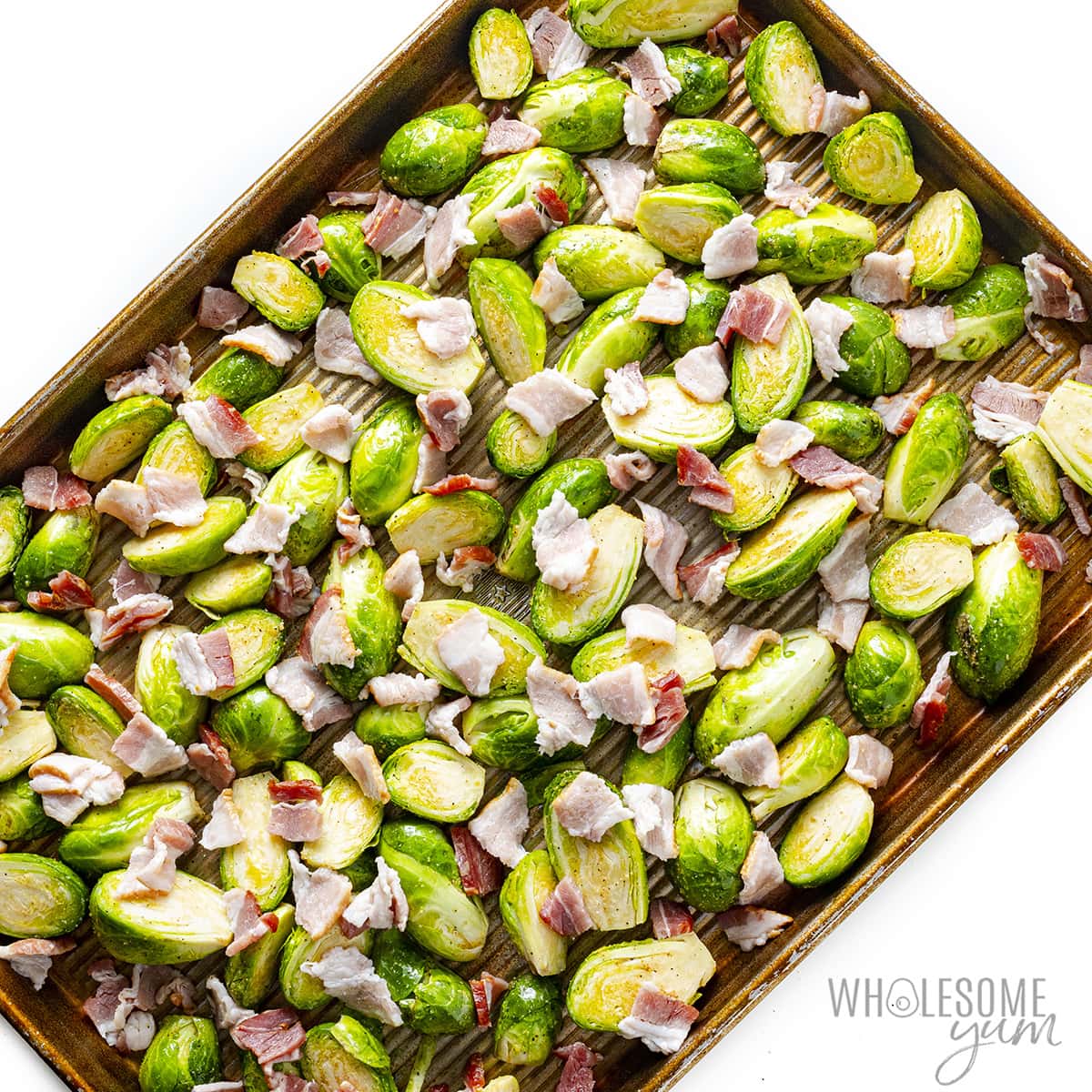 Place raw Brussels sprouts and bacon on a baking sheet.