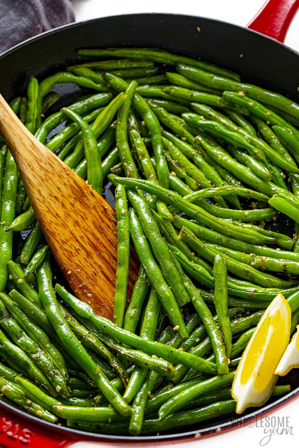 Saute green beans in skillet with wooden spoon.