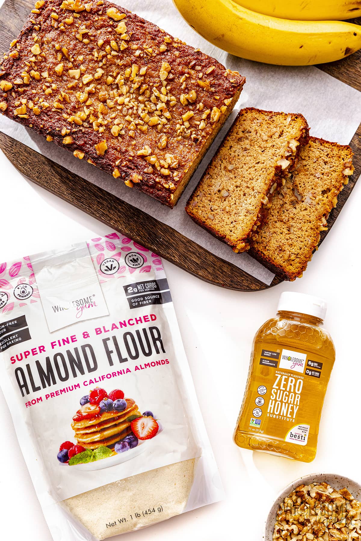 Gluten-free almond flour banana bread sliced ​​with banana and almond flour on the side.