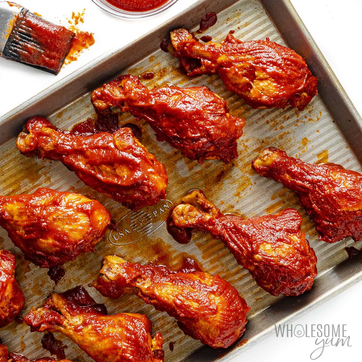 Chicken drumsticks brushed with more BBQ sauce.