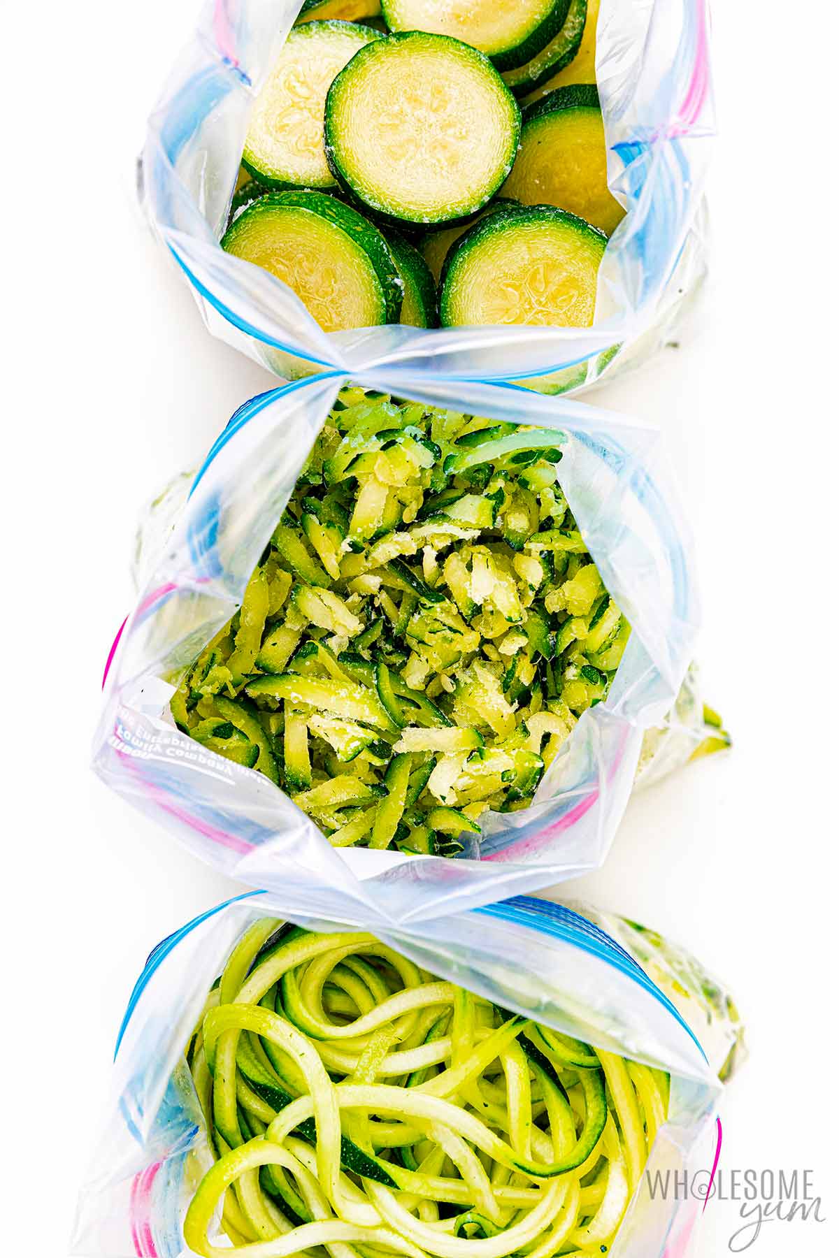 Three different types of prepared zucchini in freezer bags.