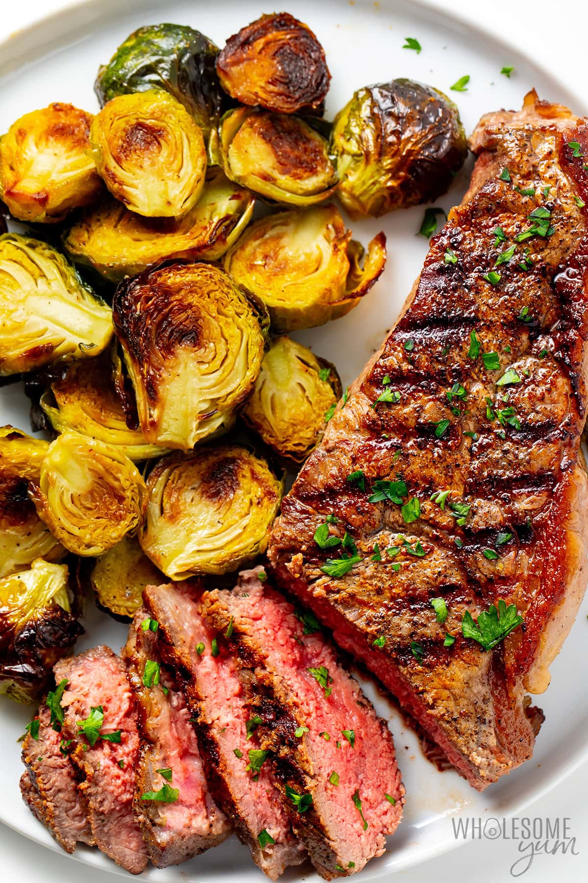 NY strip steak served with roasted brussels sprouts.