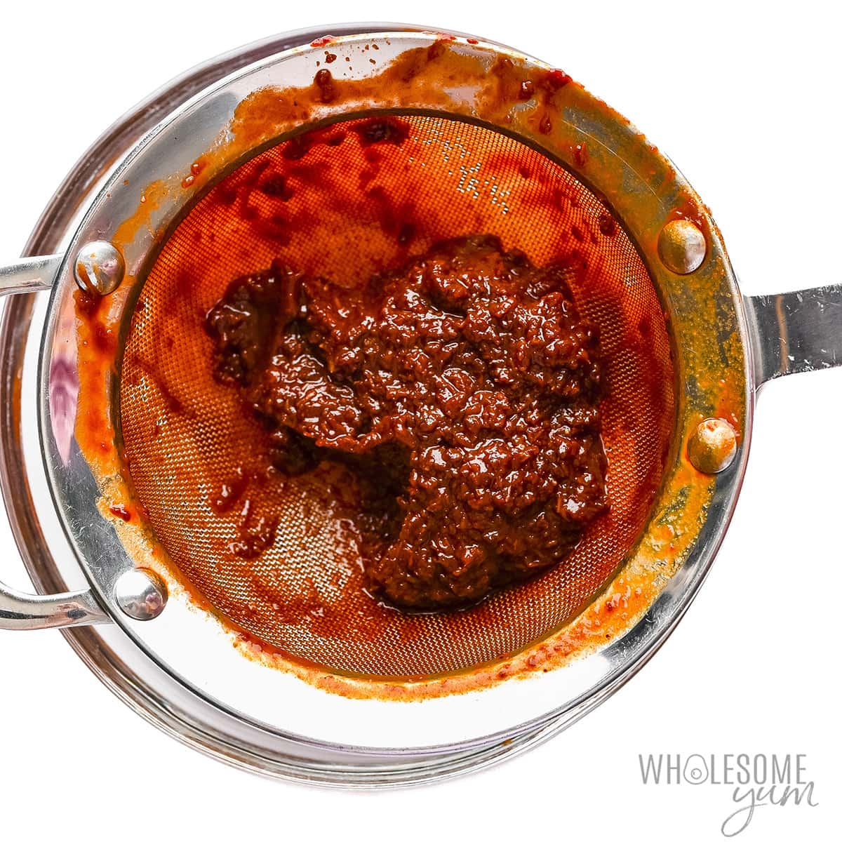 Chile paste strained into a bowl.