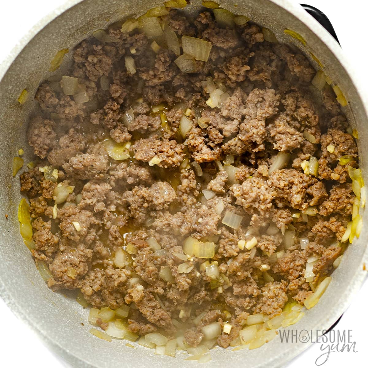 Sausage browned with other onions in a pot.