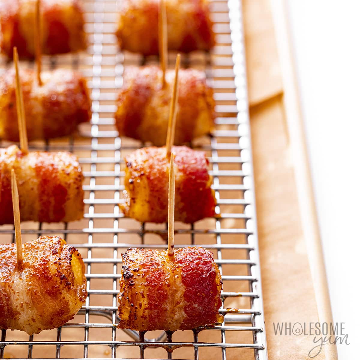 Crispy bacon wrapped chestnuts on a wire rack.