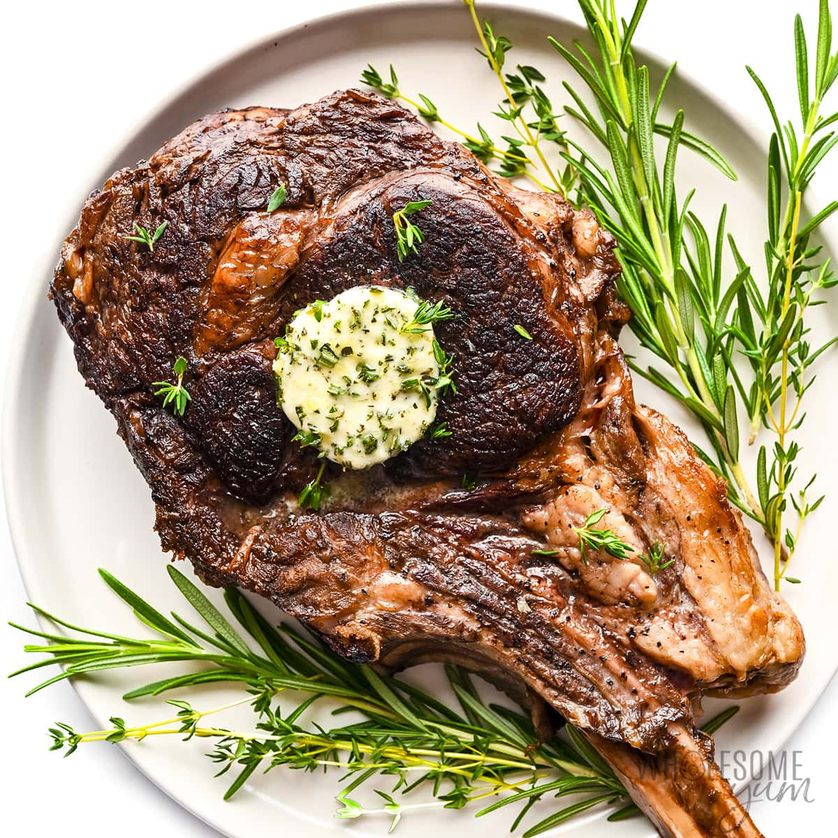 Tomahawk steak recipe topped with compound butter.