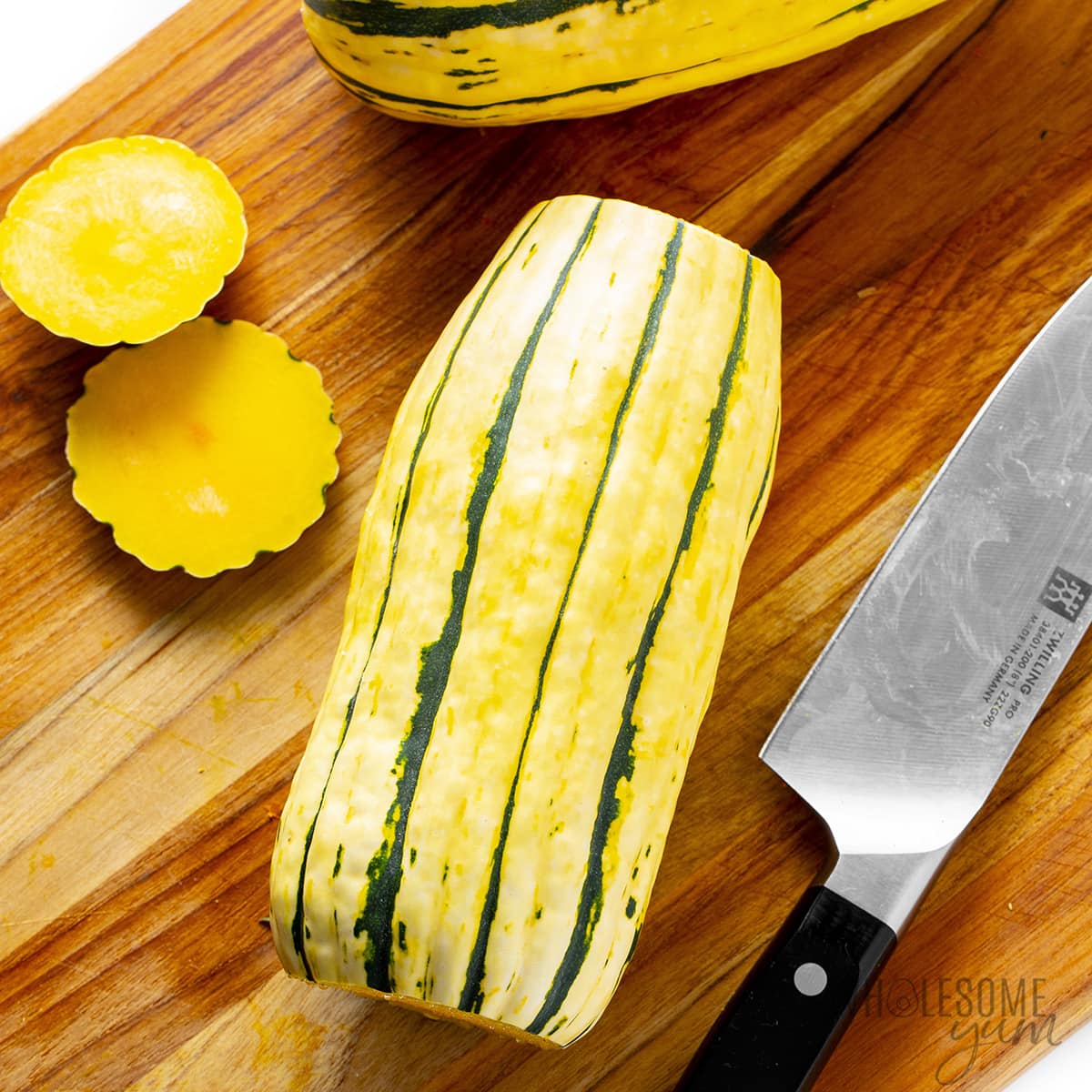 Cut the ends off the delicata squash on a cutting board.