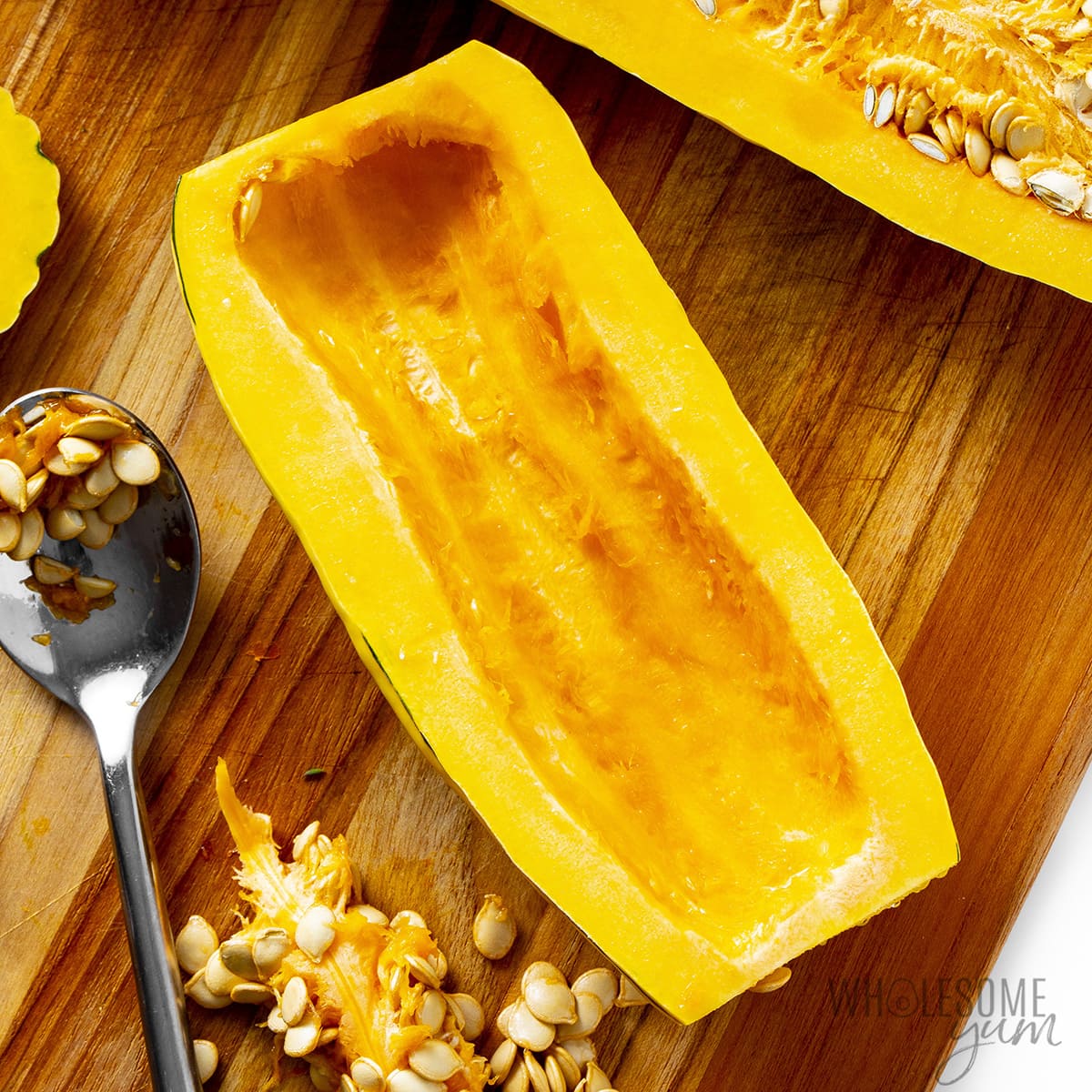 Cut delicata squash in half and scoop out seeds.