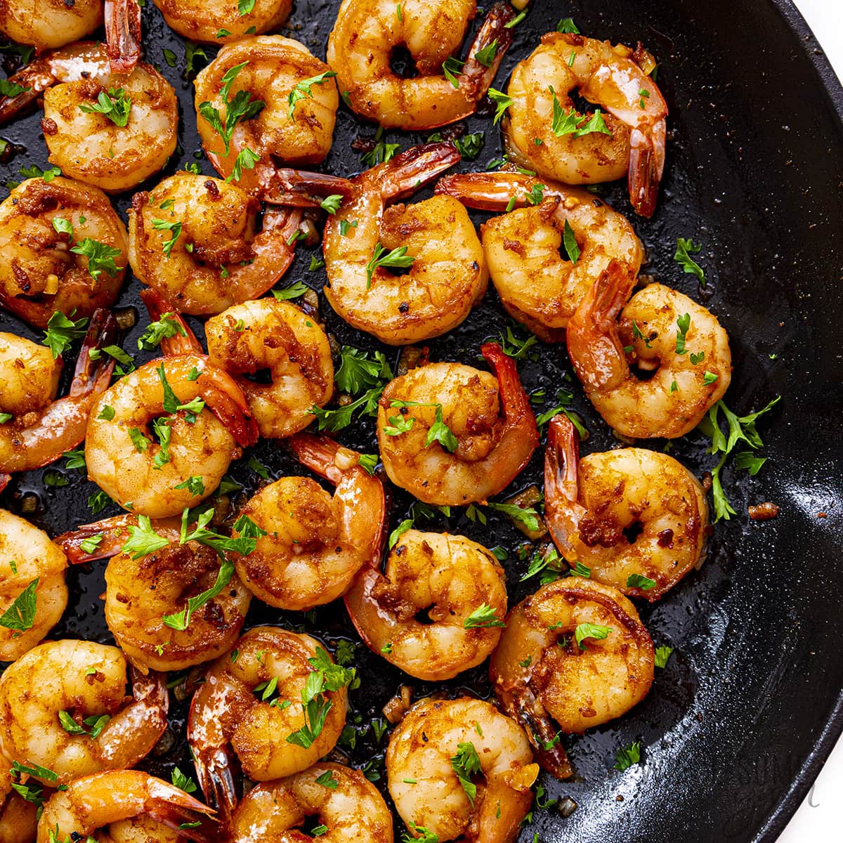 Finished sauteed shrimp in a skillet.