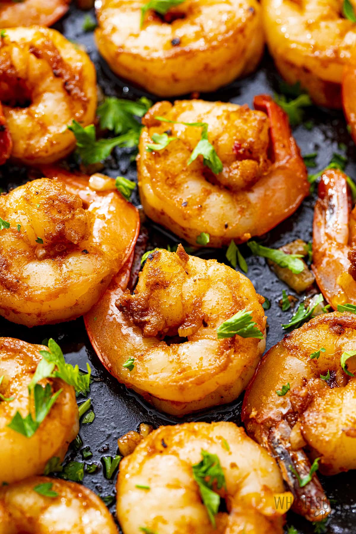 Sauteed shrimp in a skillet.
