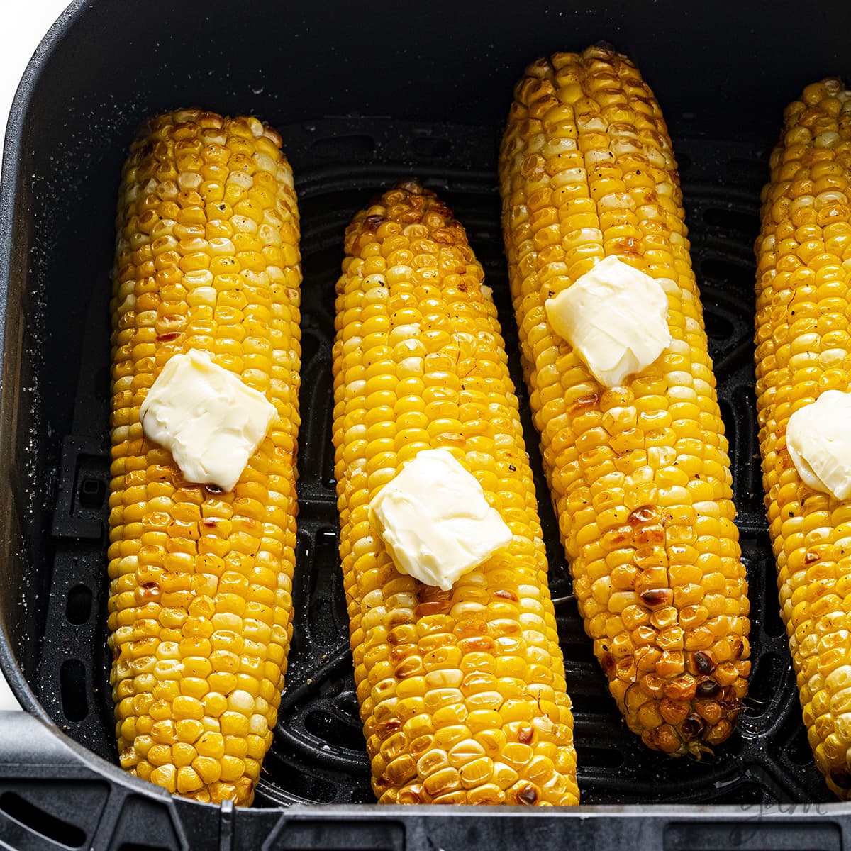 Air fryer corn on the cob, topped with butter.