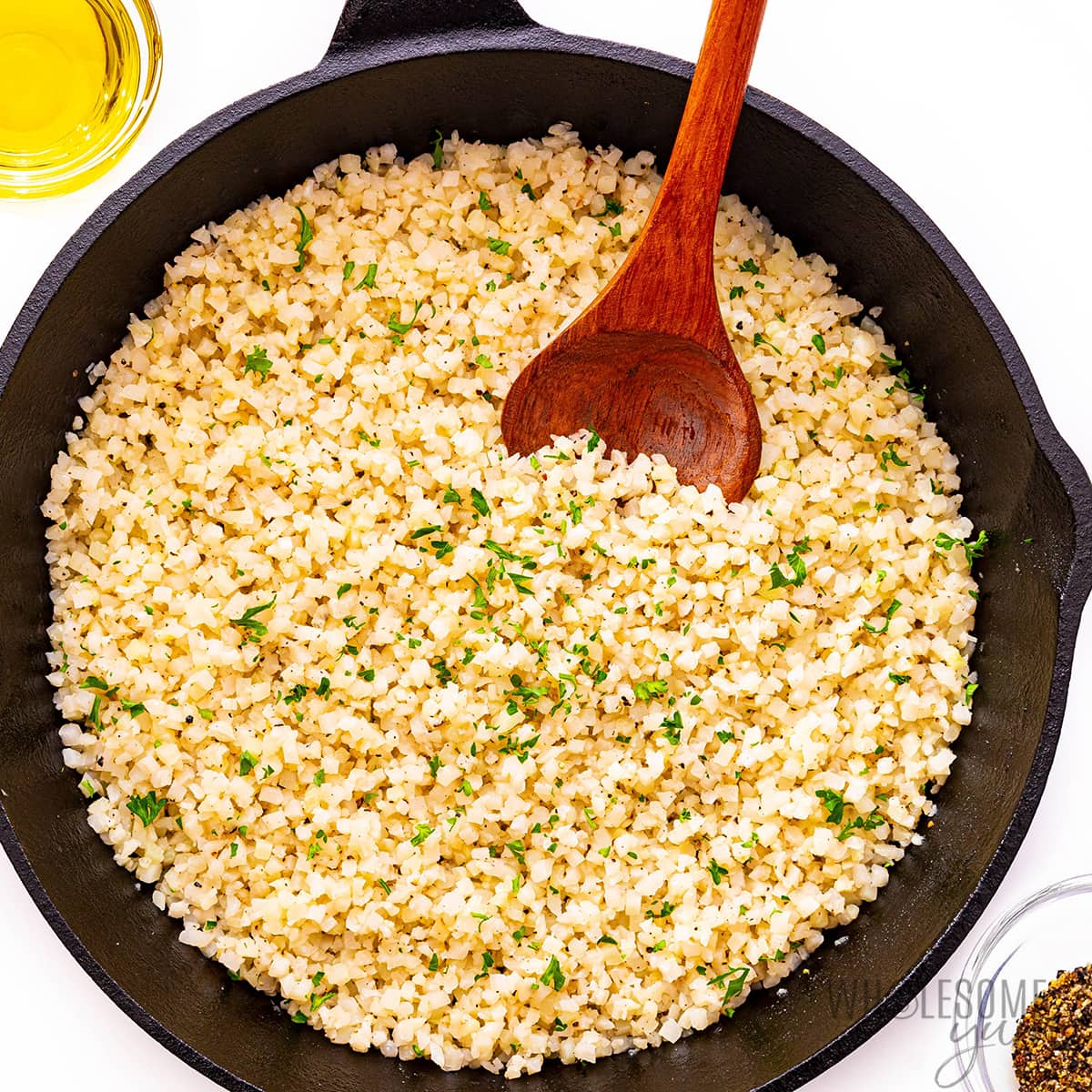 Frozen cauliflower rice with parsley in a skillet.