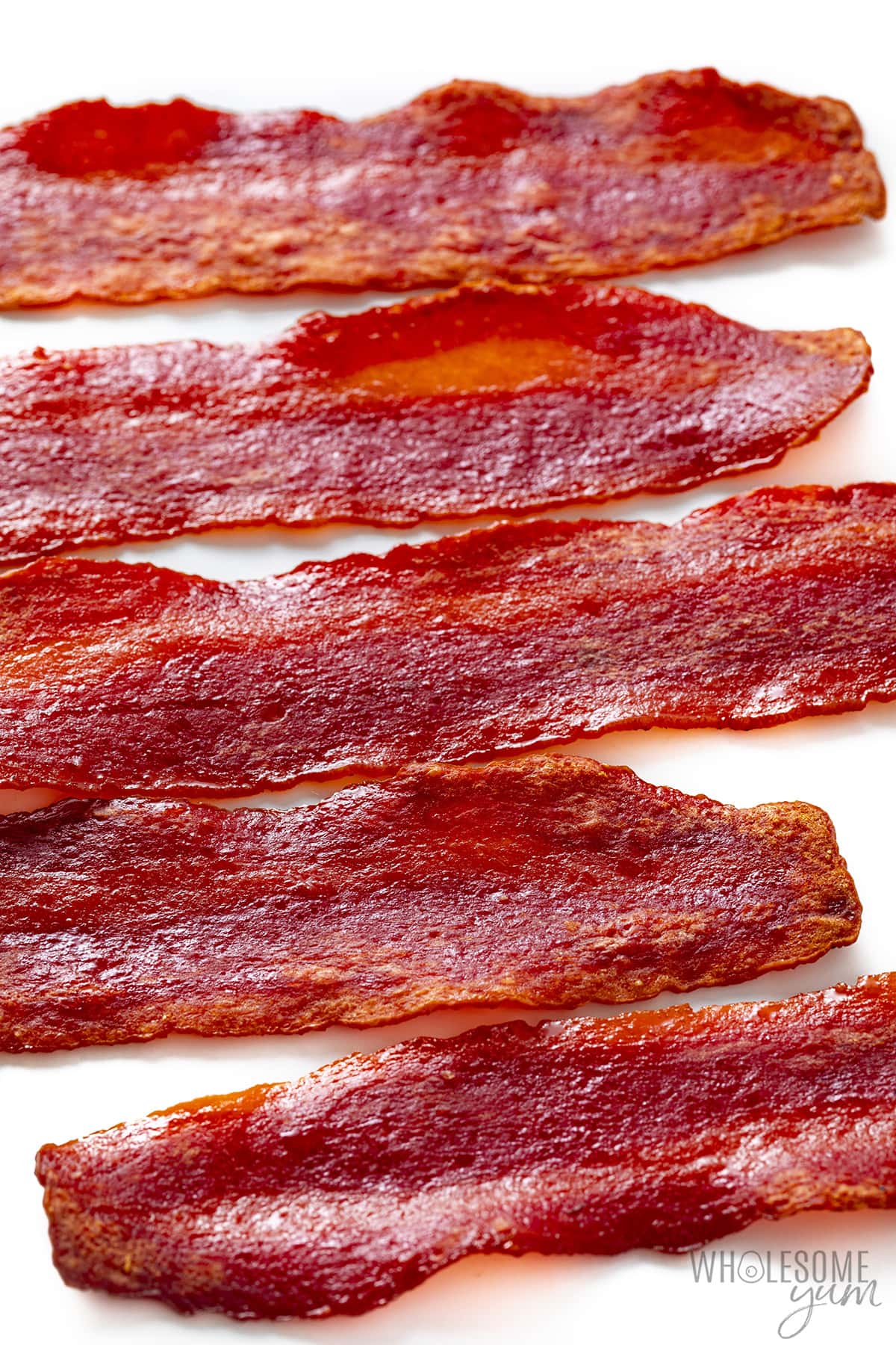 Slices of turkey bacon in the oven on a white background.