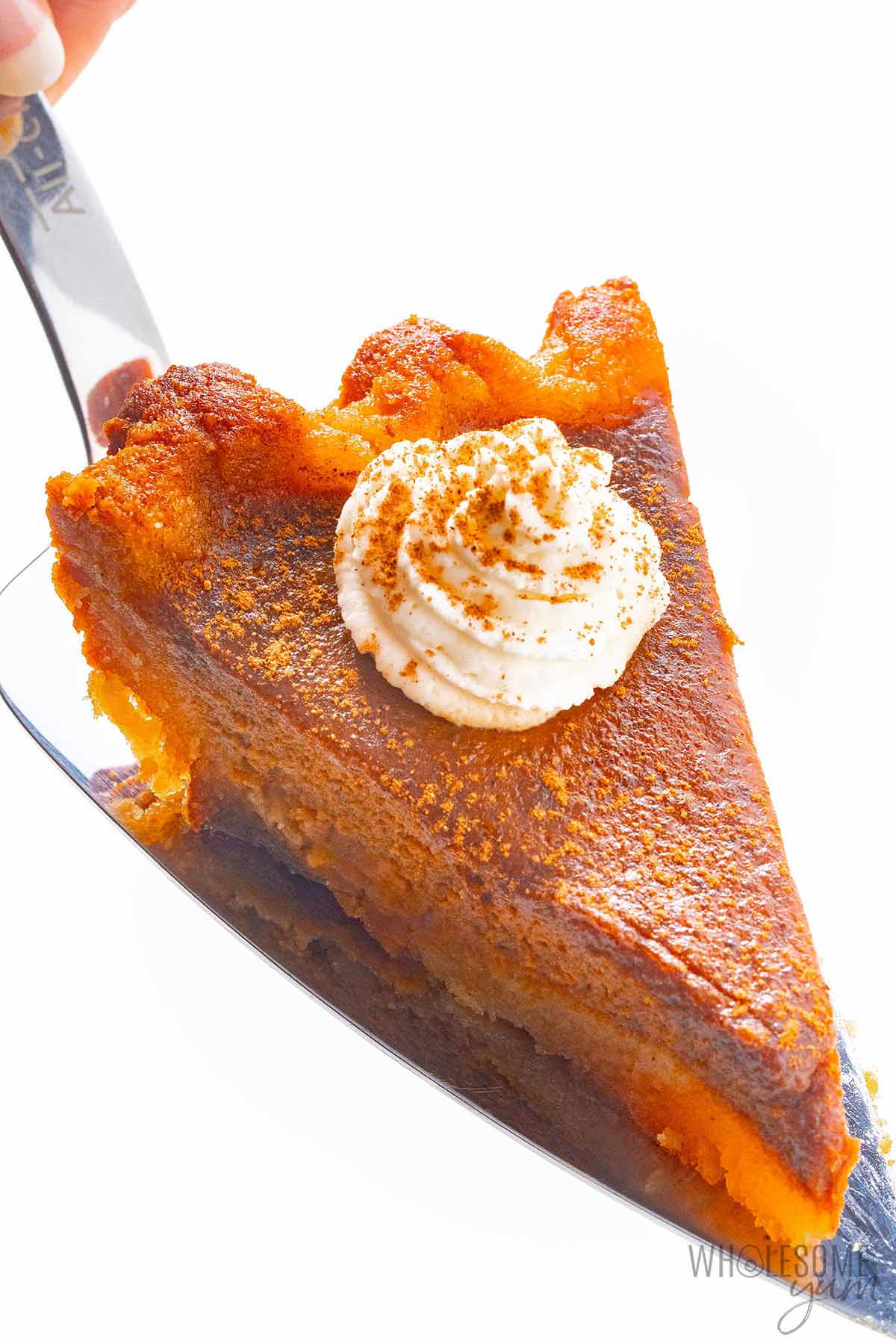Sugar free pumpkin pie slice on a spatula.