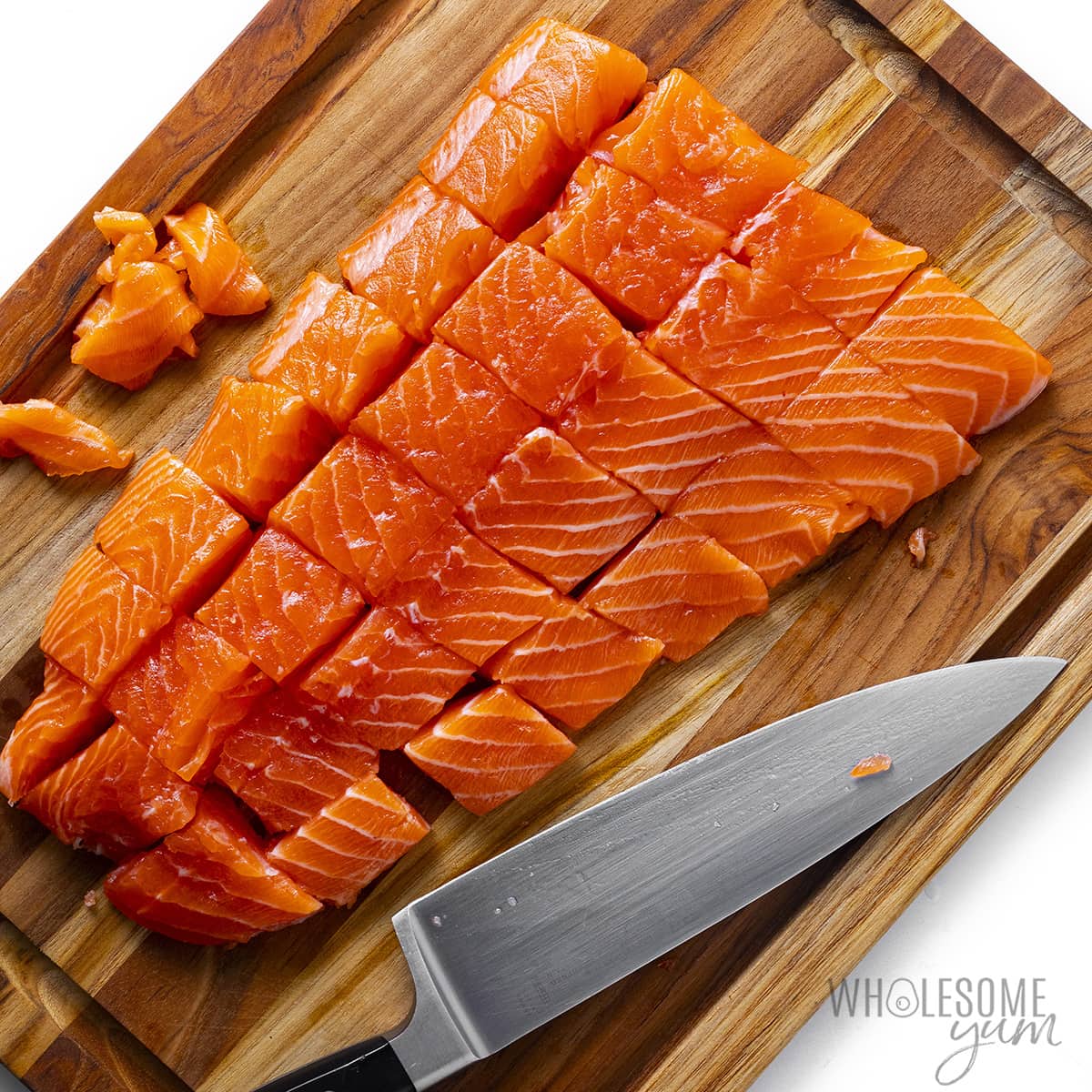 Slicing salmon into cubes.