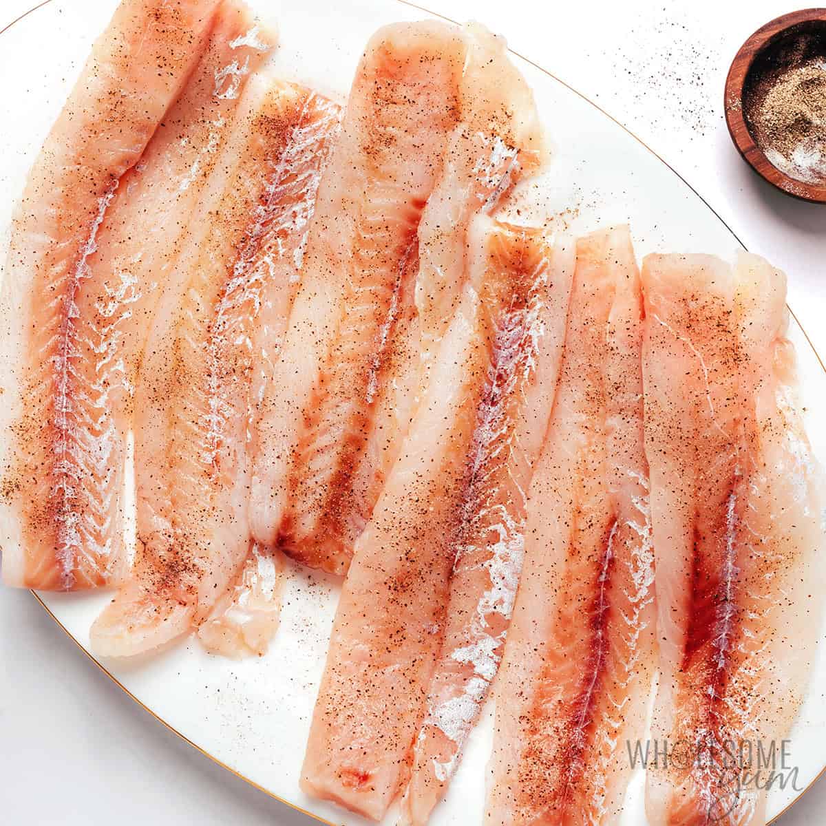 Cod fillets seasoned with salt and pepper.
