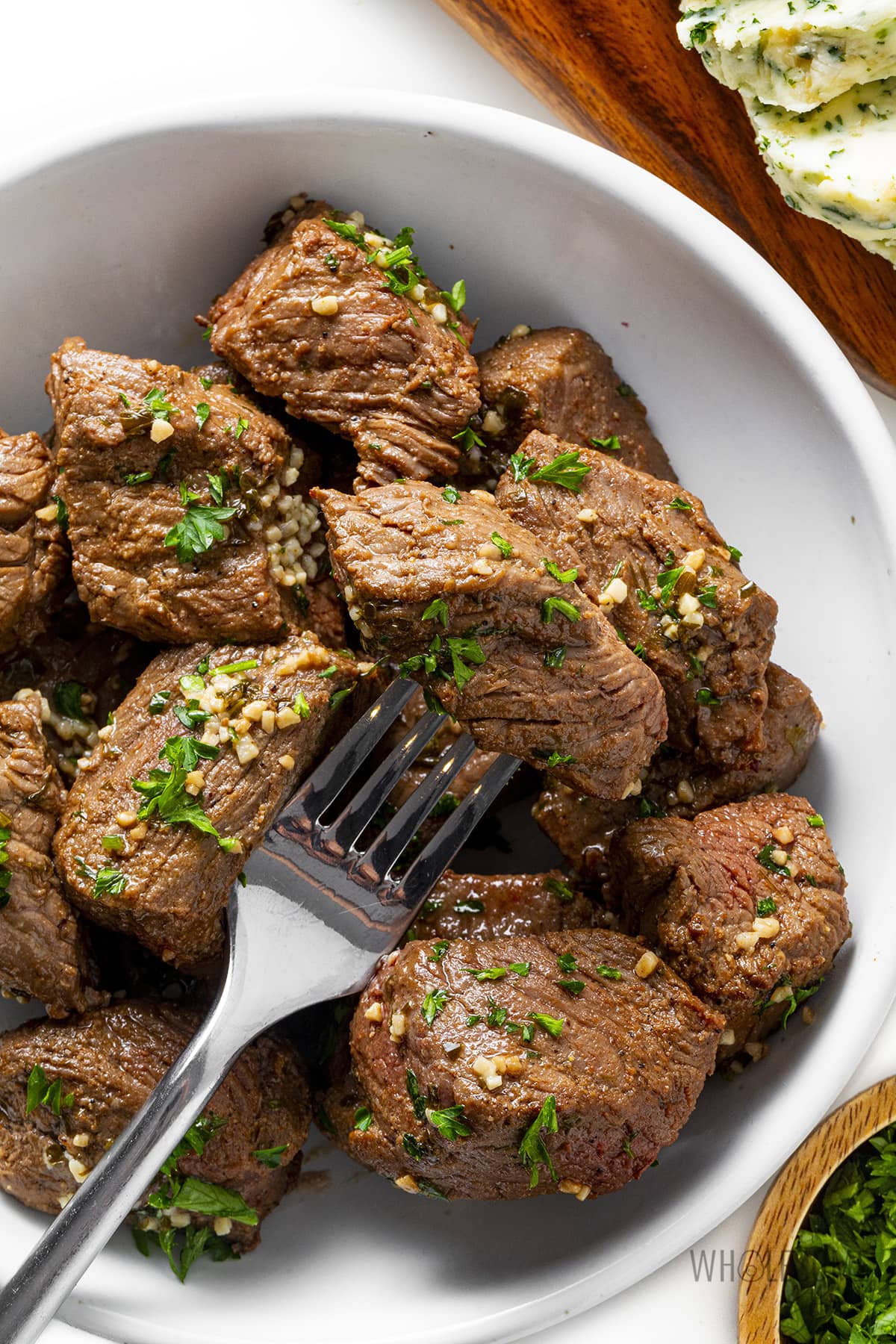 Air fryer steak bites in a bowl with fork.