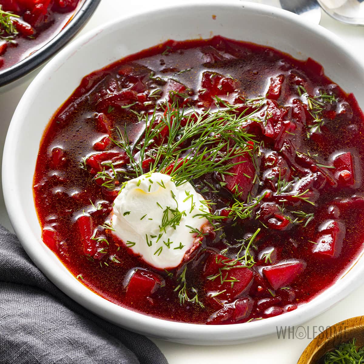 Borscht soup in a bowl with sour cream and dill.