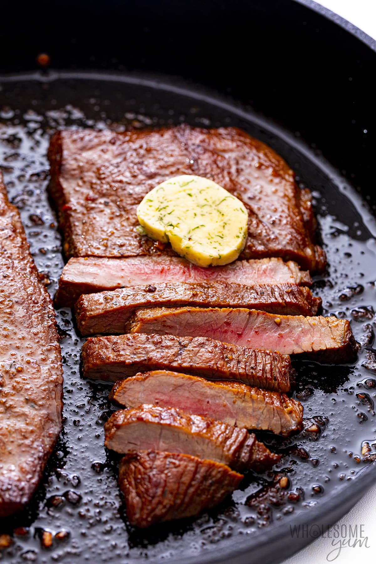 Sirloin tip steak in a pan with compound butter.