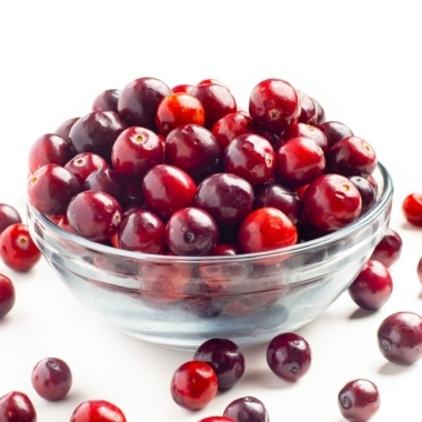 Cranberries in a bowl on white background.