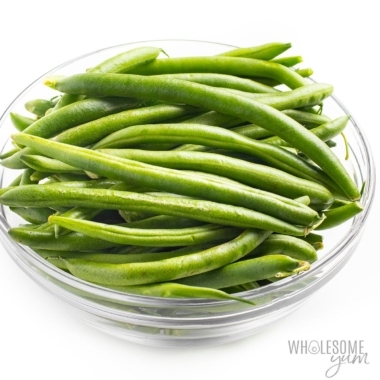 Green beans in a bowl on a white background.