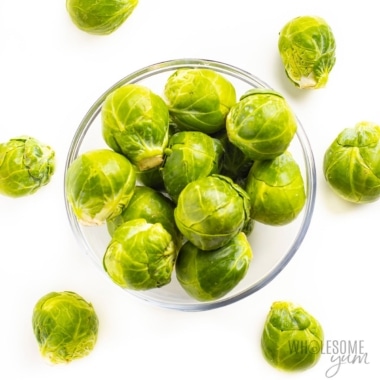 Brussels sprouts in bowl on white background.