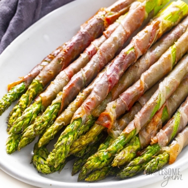 Prosciutto wrapped asparagus on a platter.