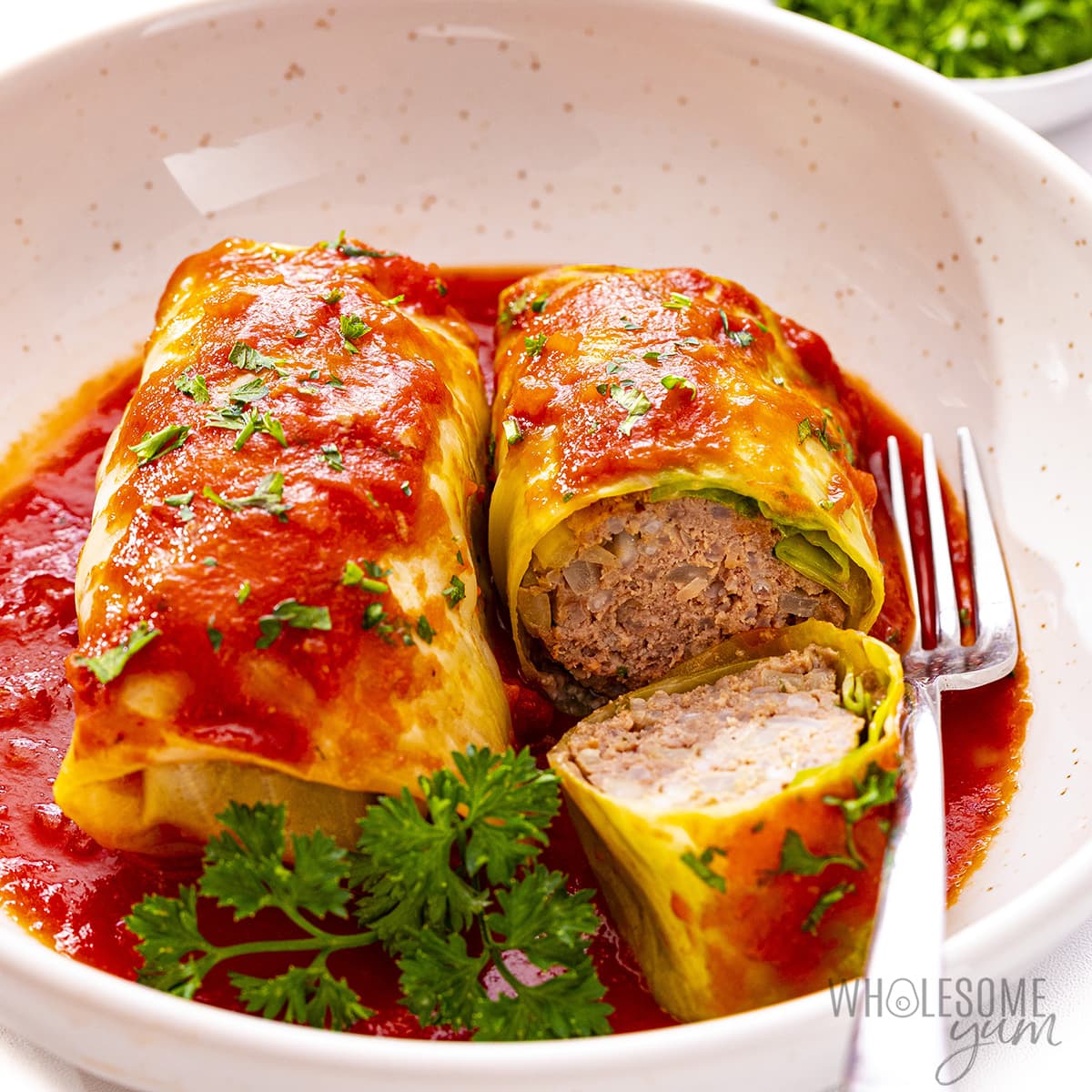 Stuffed cabbage rolls on a plate with a fork.